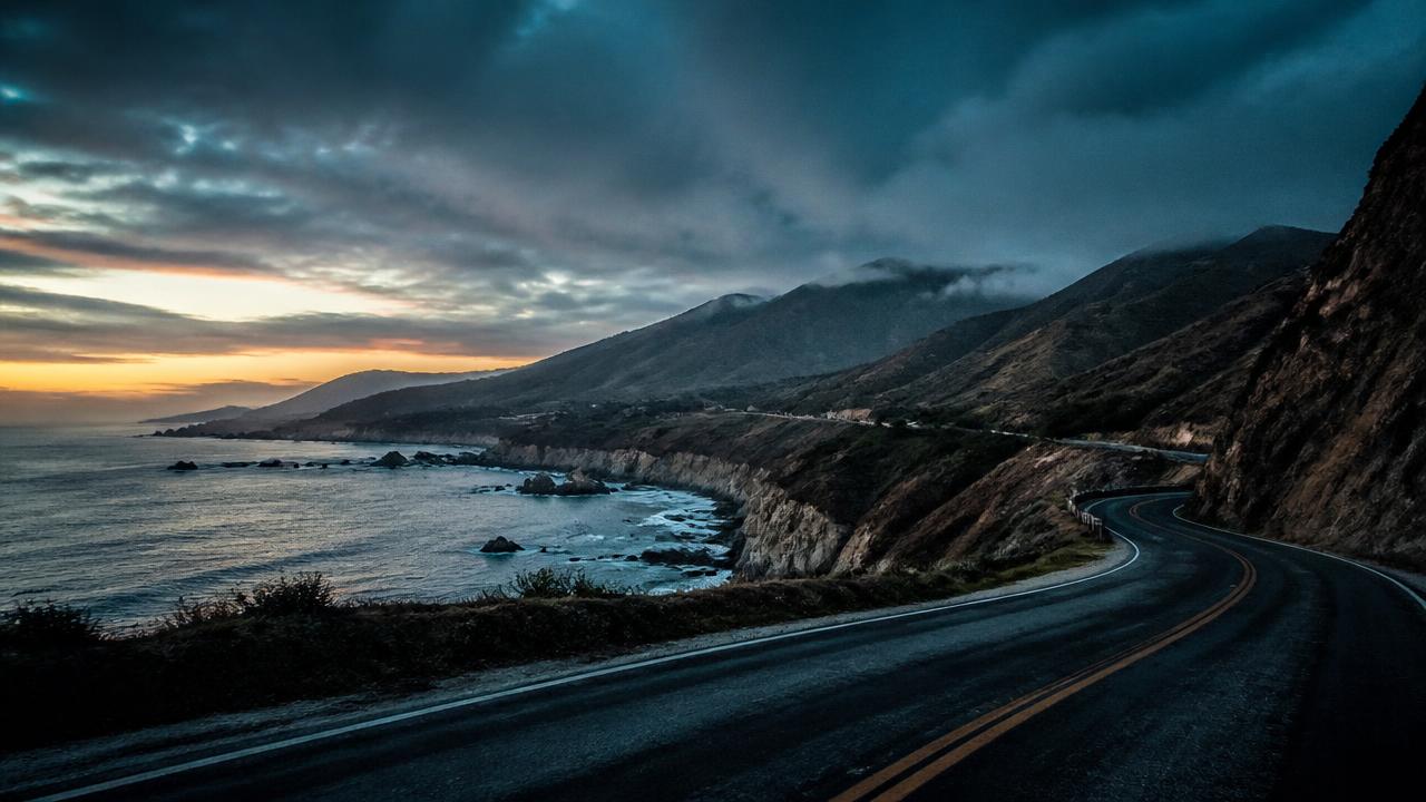 Cinematic coastal mountain road at dusk