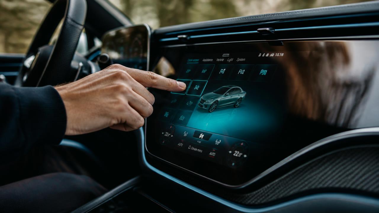 Cinematic close-up of a hand interacting with a modern curved car touchscreen interface